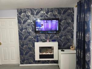 a living room with a tv on a wall at Stylish and Comfortable Home in Beeston