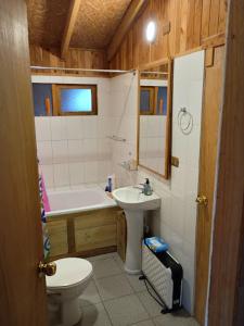 a bathroom with a toilet and a sink and a tub at Casa de Campo in Ancud