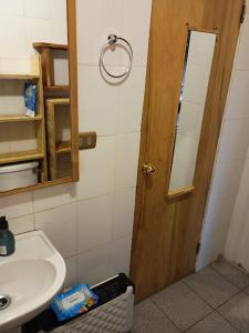 a bathroom with a sink and a wooden door at Casa de Campo in Ancud +40 photos