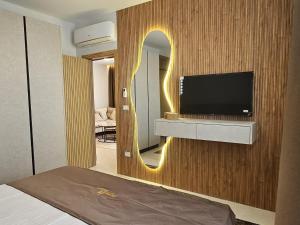 a living room with a tv and a mirror at Nova Apartments Golem in Golem
