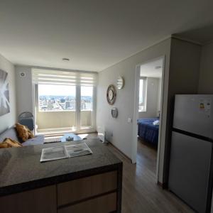 a kitchen and living room with a refrigerator and a window at Vanguardia 924 in Temuco