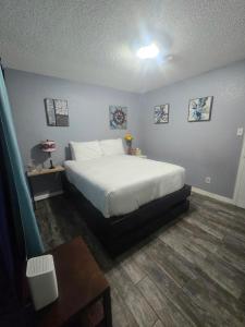 Un dormitorio con una cama blanca y una mesa. en 5BR3BA Home, 2 Blocks from Beach, ADA Accessible, en Galveston