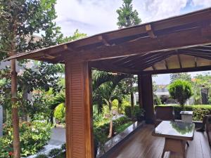 une pergola en bois avec une table sur une terrasse en bois dans l'établissement WahikaStay, à Masindi
