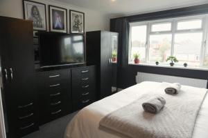 レイランドにあるDetached Homestay - Super, King & Double Rooms - Leyland, Preston, Chorley, Lancashireのベッドと薄型テレビのある寝室