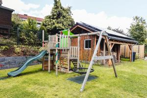 ein Spielplatz mit Rutsche und einem Haus in der Unterkunft Apartment Morgentau, mit Aussicht in Wieda & großzügigen Garten in Walkenried