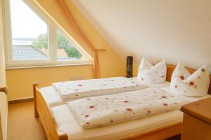 two twin beds in a room with a window at Ferienwohnung Seeblick am Fleesensee in Göhren-Lebbin