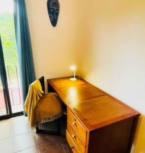 Un escritorio de madera con una vela encima. en Cozy and Peaceful Beach Apartment, en Playa Grande 3 fotos más