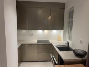a kitchen with brown cabinets and a sink at Apartamenty Wilenska in Słupsk +5 photos