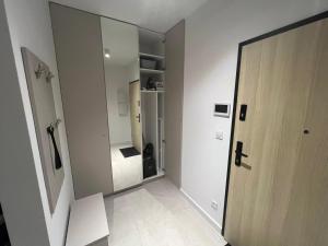 a hallway with a large mirror and a door at Apartamenty Wilenska in Słupsk