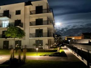a large white building with the moon in the sky at Apartamenty Wilenska in Słupsk