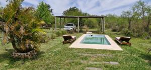 a pool in a yard with two chairs and a truck at Aires del Ibera in Colonia Carlos Pellegrini