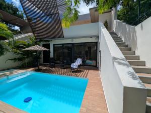 a swimming pool in front of a house at Luxury 4 Bedroom Villa with Private Pool in Tulum