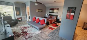 a living room with a couch and a bed with red pillows at Luxury Private Studio, Quiet, Residential Area in Katy