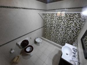 y baño con aseo, lavabo y ducha. en Complejo AIKA - Balneario Marisol - Oriente, en Balneario Oriente 34 fotos más