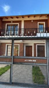 una valla delante de un edificio de ladrillo en Depto nqn, en Neuquén