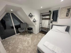 a bedroom with a bed and a chair and a ladder at The Diamond Retreat in Purley