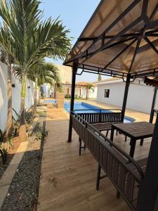 a couple of benches with umbrellas next to a pool at Three-bedroom with Pool Two Suites in a Gated Community in Belas