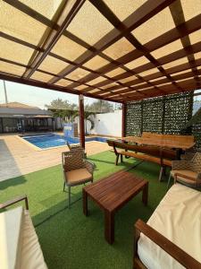 a patio with benches and a table and a pool at Three-bedroom with Pool Two Suites in a Gated Community in Belas