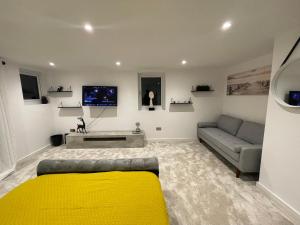 a living room with a yellow bed and a couch at The Diamond Retreat in Purley