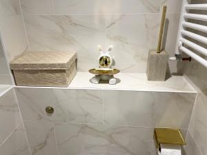 a bathroom with a shelf with a toy on it at The Diamond Retreat in Purley +60 photos