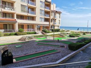 an apartment building with golf courses in front of the ocean at Апартамент E003 в Обзор Бийч Резорт - усещането да живееш на плажа!! in Obzor