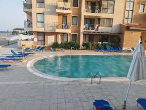 a swimming pool in front of a building at Апартамент E003 в Обзор Бийч Резорт - усещането да живееш на плажа!! in Obzor