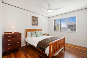 a bedroom with a bed and a dresser and a window at Peaceful and Tranquil ~ Koala Beach in Pottsville