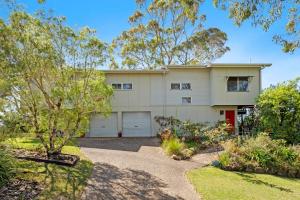 a house with two garage doors in a yard at Peaceful and Tranquil ~ Koala Beach in Pottsville