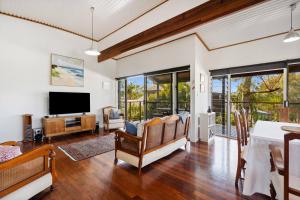 a living room with a television and a table at Peaceful and Tranquil ~ Koala Beach in Pottsville