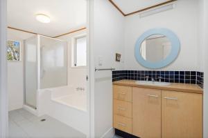 a bathroom with a shower and a sink and a mirror at Peaceful and Tranquil ~ Koala Beach in Pottsville +25 photos