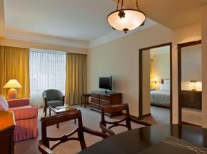 a hotel room with a living room with a bed at Hospedium Princess Hotel Panam&aacute; in Panama City