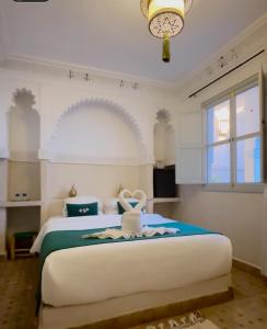 Un dormitorio con una gran cama blanca y una ventana. en Riad Magnolia&SPA, en Marrakech