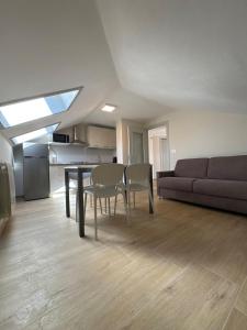 ein Wohnzimmer mit Tisch und Stühlen und einer Couch in der Unterkunft La casa i due cedri in Cuneo