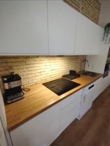 een keuken met witte kasten en een houten aanrechtblad bij Life in the Center of Valencia - Fast Wiffi in Valencia