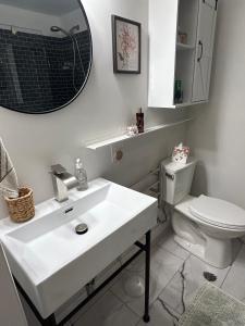 ein Badezimmer mit einem weißen Waschbecken und einer Toilette in der Unterkunft Beautiful & peaceful studio with private entrance 