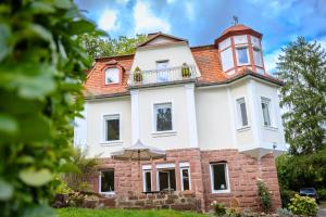 a building with an umbrella in front of it at Ferienwohnung Villa Waldeck, Alleinlage - Eigene Sonnenterrasse - Küche in Bad Kissingen