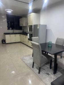 Una cocina con una mesa y sillas en una habitación. en Kachimam Luxury Apartment, en Kitwe