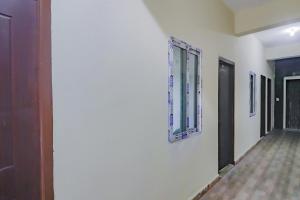 a hallway with a white wall and a window at Hotel O Sri Residency in Hyderabad