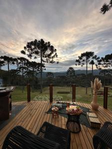 a deck with chairs and a table with a view at Cabana Bergamo, Villa Itália - Urubici in Urubici