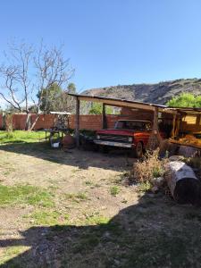a truck parked under a shed in a field at Casa tranquila en contacto con la naturaleza in Sucre