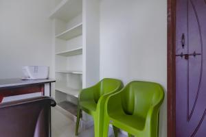 two green chairs sitting next to a shelf at Hotel O Sri Residency in Hyderabad +34 photos