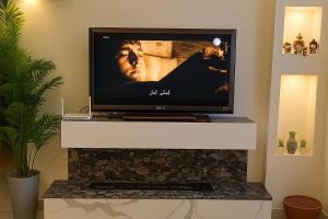 a flat screen tv sitting on top of a fireplace at Modern Apartment in Amman in Amman
