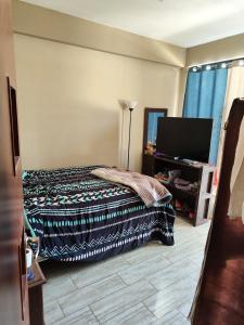 a bedroom with a bed and a flat screen tv at Casa tranquila en contacto con la naturaleza in Sucre