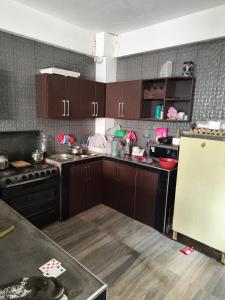 a kitchen with brown cabinets and a white refrigerator at Casa tranquila en contacto con la naturaleza in Sucre