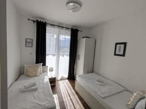 ein Zimmer mit zwei Betten und einem Fenster in der Unterkunft Pinocchio in Bihać