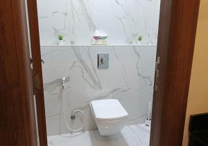 a white bathroom with a toilet and marble walls at Modern Apartment in Amman in Amman +11 photos