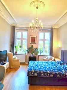 a bedroom with a blue bed and a chandelier at 1 Bedroom Lux Apartment Center Vincent in Wrocław