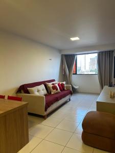 a living room with a couch and a window at Apart amplo, equipado e cama king in João Pessoa +11 photos