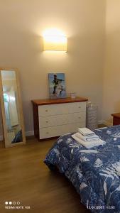 a bedroom with a bed with a dresser and a mirror at Nonno 'Drea Guest House in Castiglione della Pescaia