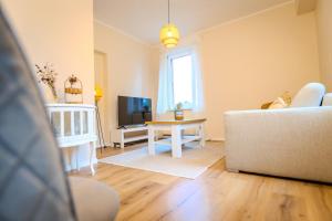 a living room with a couch and a table at Ferienwohnung Villa Waldeck, Alleinlage - Eigene Sonnenterrasse - Küche in Bad Kissingen